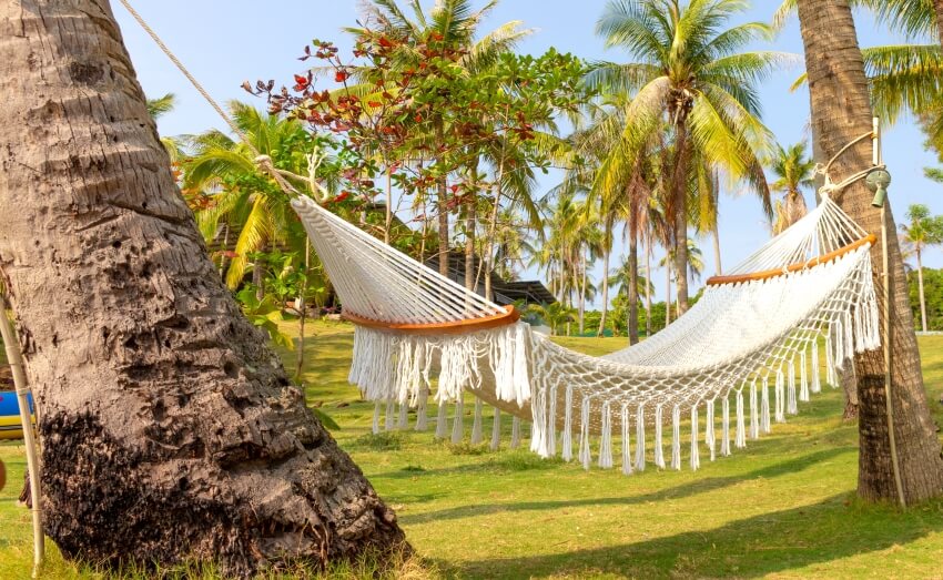 An empty Mayan hammock in the shade of trees for relaxation on a tropical island