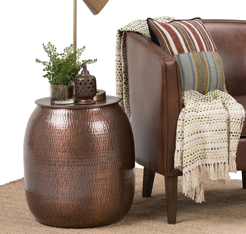 Antique copper drum sofa table and storage beside a leather sofa