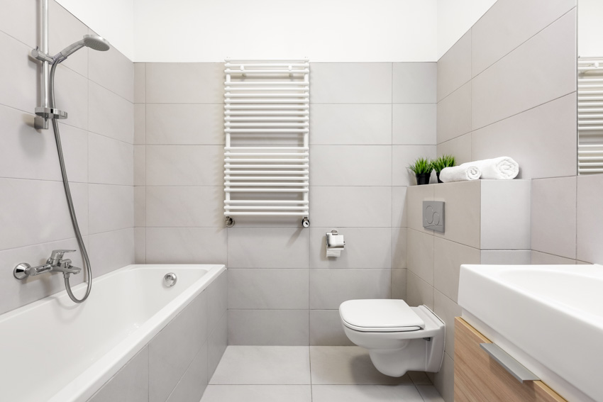 Bathroom with acrylic tub, toilet, showerhead, and sink