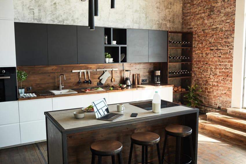 Beautiful kitchen with island stove, stools, cabinets, wood backsplash, and accent wall
