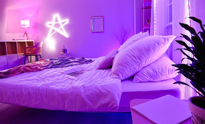 Bedroom with neon lighting, bed, cubby hole storage, chair, and indoor plant