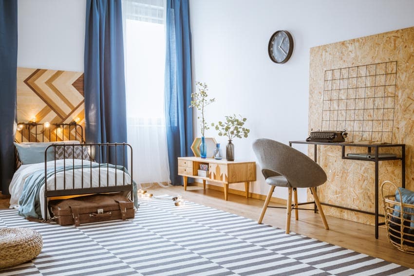 Bedroom with patterned floor, dresser, corkboard wall and clock