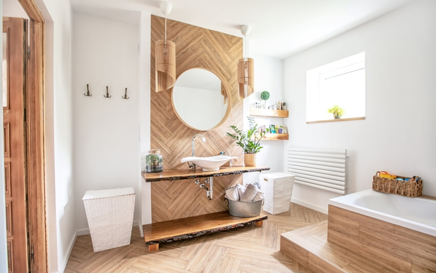 Boho style bathroom with white sink on wall mounted wood countertop with a round mirror hanging above it