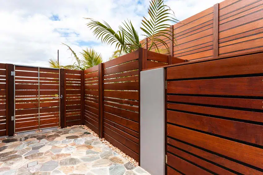 Composite fencing with brown stained panels