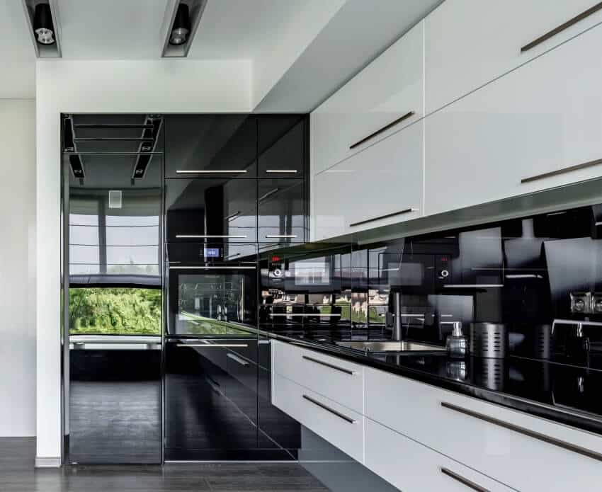Contemporary kitchen in black and white with wood floor and glossy cabinets