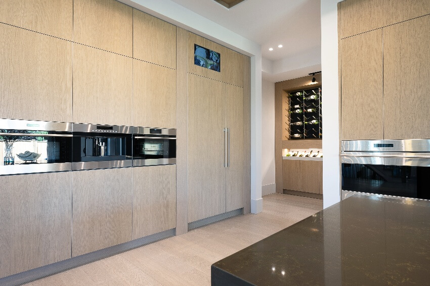 Contemporary kitchen with wine rack, wood laminate cabinets, and granite counters