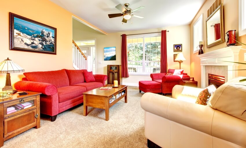 Cozy classic peach and red room with fireplace and table with storage and lamp