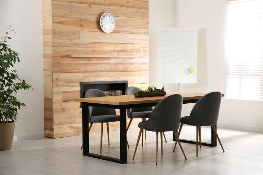 Dining area with wood accent, black chairs and windows with blinds