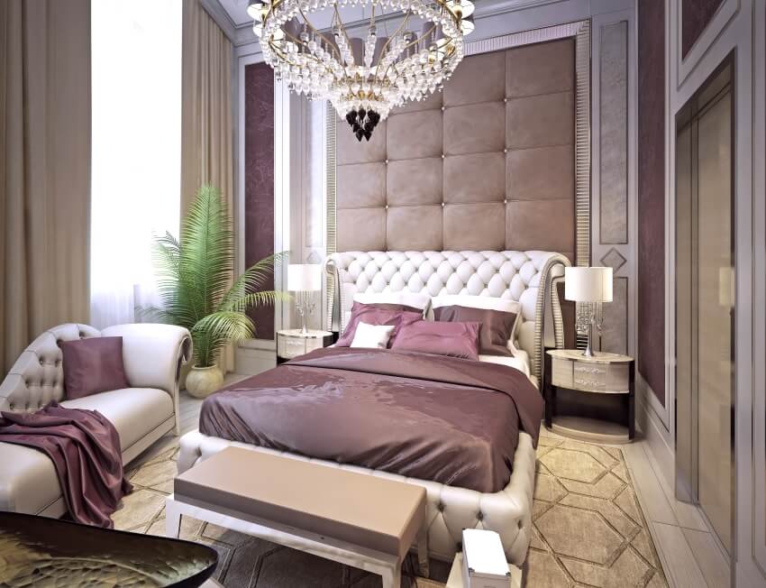 Elegant bedroom with upholstered wall behind bed, carpet floor, and a chandelier