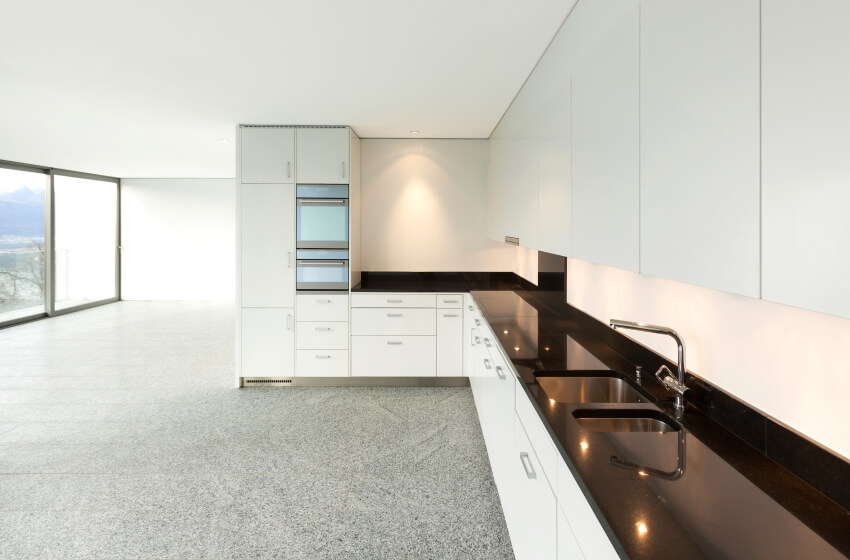 Empty apartment with panoramic windows, terrazzo floor, and long kitchen counter