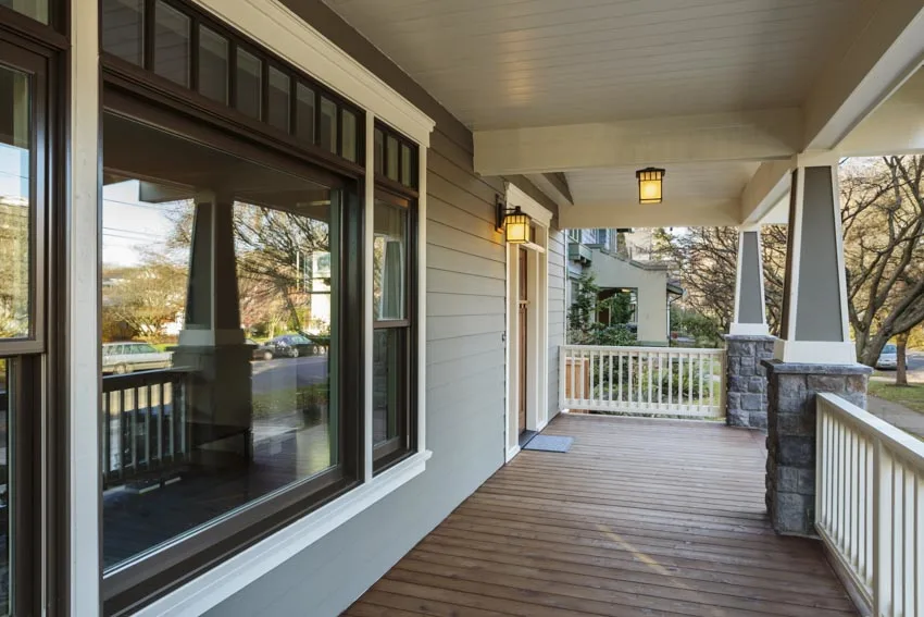 Front porch with windows, wood floor, siding, and ceiling lights