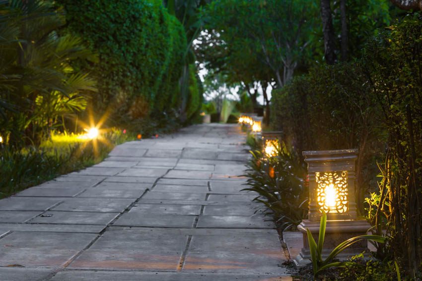 Garden with pathway, hedges, and outdoor lighting fixtures