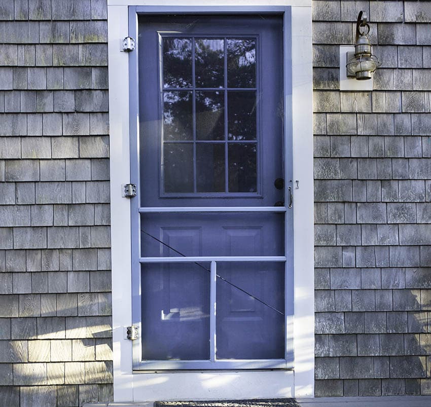 Hinged screen door on house front porch