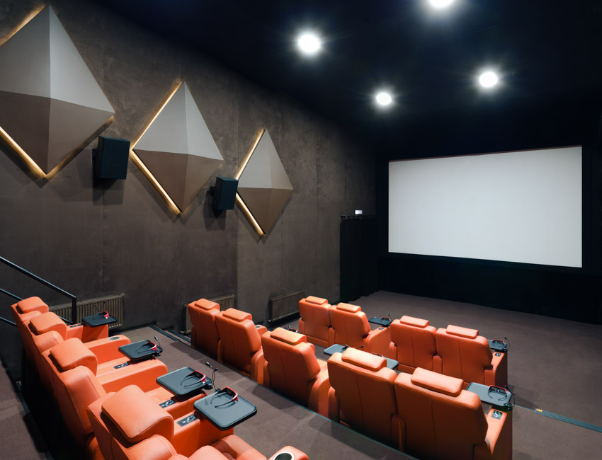 Home theater with painted walls, red sofa seats, and ceiling lights