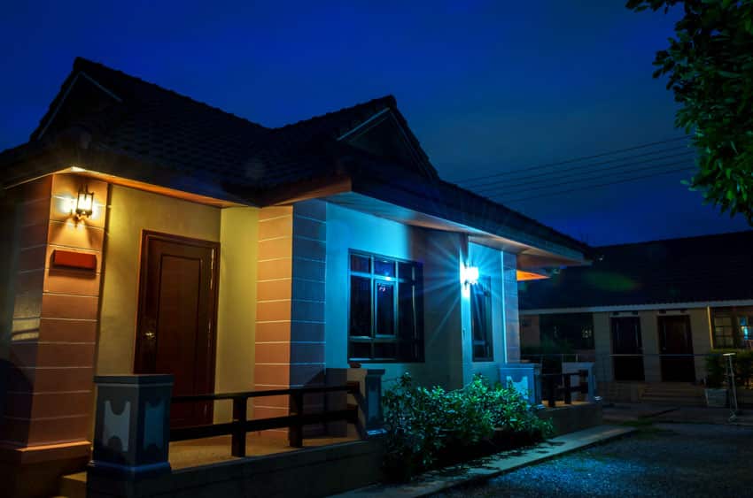 House exterior with color changing wall mounted light, front door, and windows