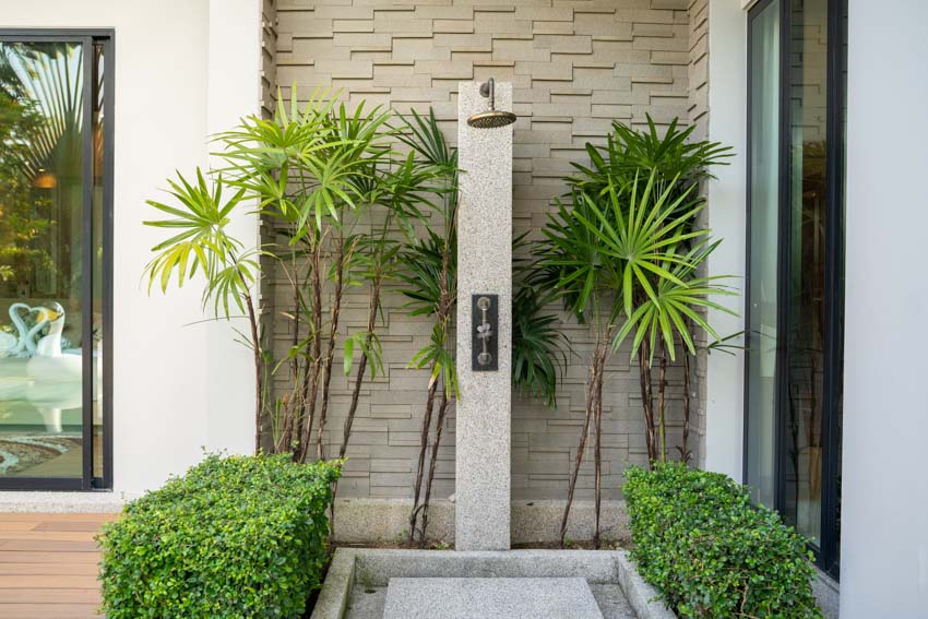 Outdoor shower with accent wall and glass doors