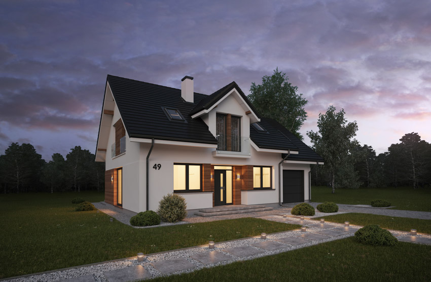 House exterior with pitched roof, windows, door, chimney, and landscape lights