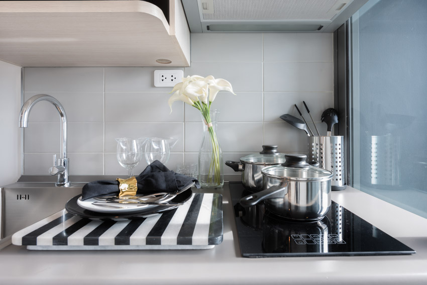 Kitchen countertop with induction, stove, black, and white ceramic heat protector