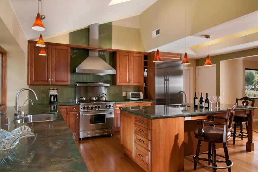 Kitchen with center island, green marble countertop, wood cabinets, backsplash, and range hood