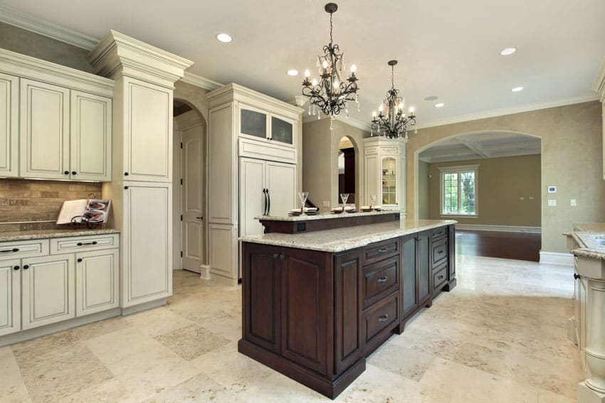 Kitchen with center island, leathered quartzite countertop, tile floor, and white cabinets