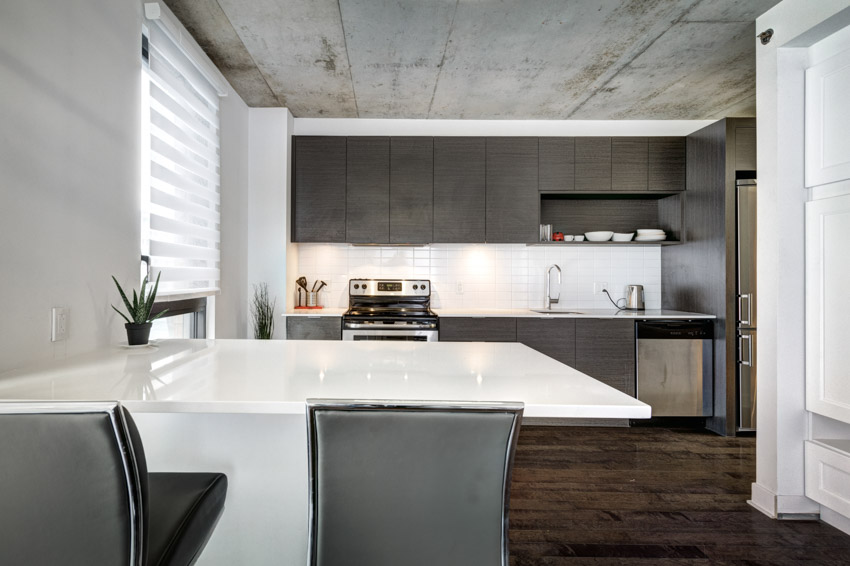 Kitchen with countertop, dark floors, black cabinets, and windows