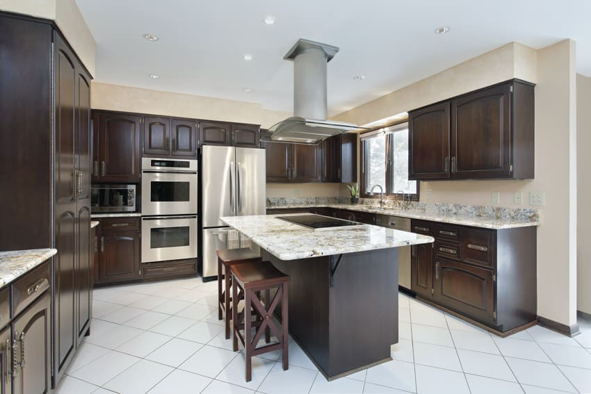 Kitchen with dark wood, cabinets, tile flooring, center island, stove, and range hood