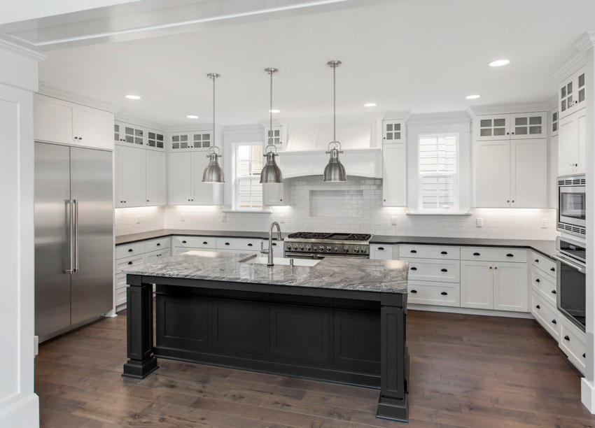 Kitchen with dark wood floor, center island, countertop, white cabinets, and pendant lights
