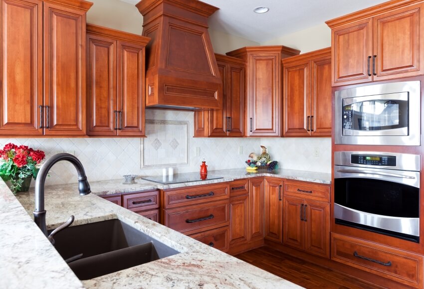 Kitchen with granite countertops, white tile backsplash, and cherry cabinets