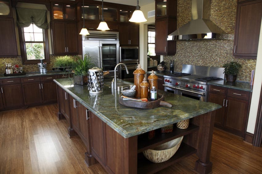 Kitchen with green marble countertop, center island, backsplash, range hood, cabinets, window, and wood floors