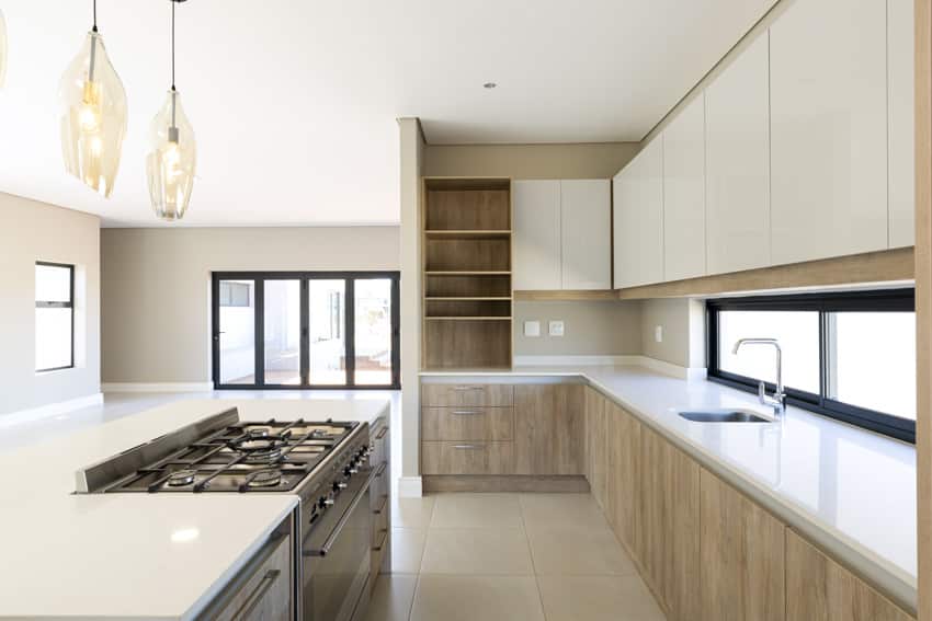 Kitchen with white laminate countertops, cooktop island and veneer cabinets