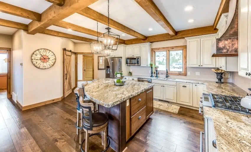 Kitchen with wood beams on ceiling, white cabinets, brown shaded marble countertops, and wood flooring