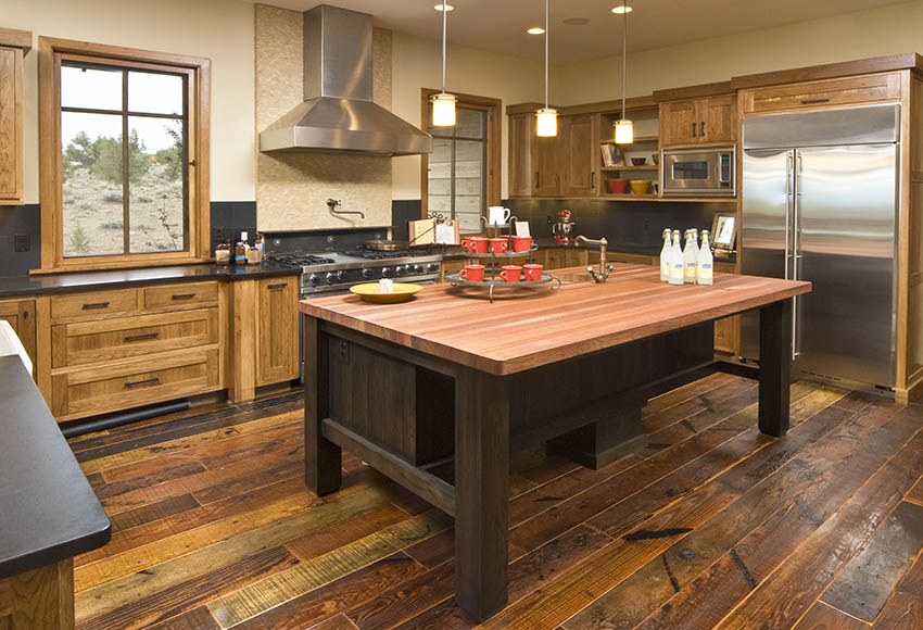 Beautiful kitchen with wood interior, a redwood countertop island and pendant lights
