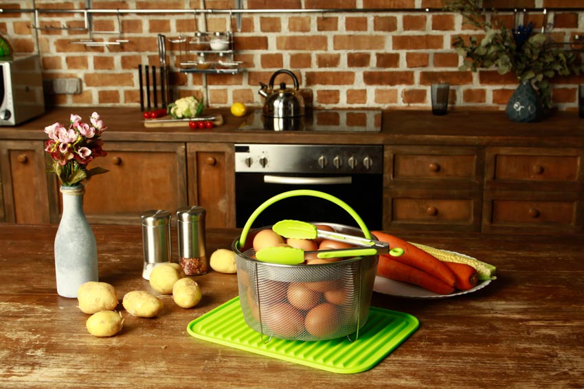 Kitchen with wood surface countertop, silicone mat, drawers, and backsplash