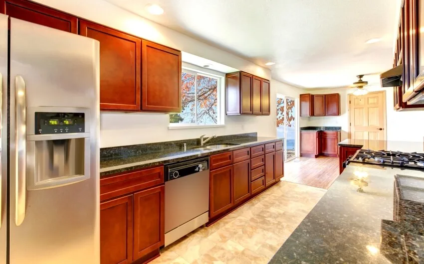 Large bright kitchen with dark cherry cabinets, stainless steal appliances, and granite countertops