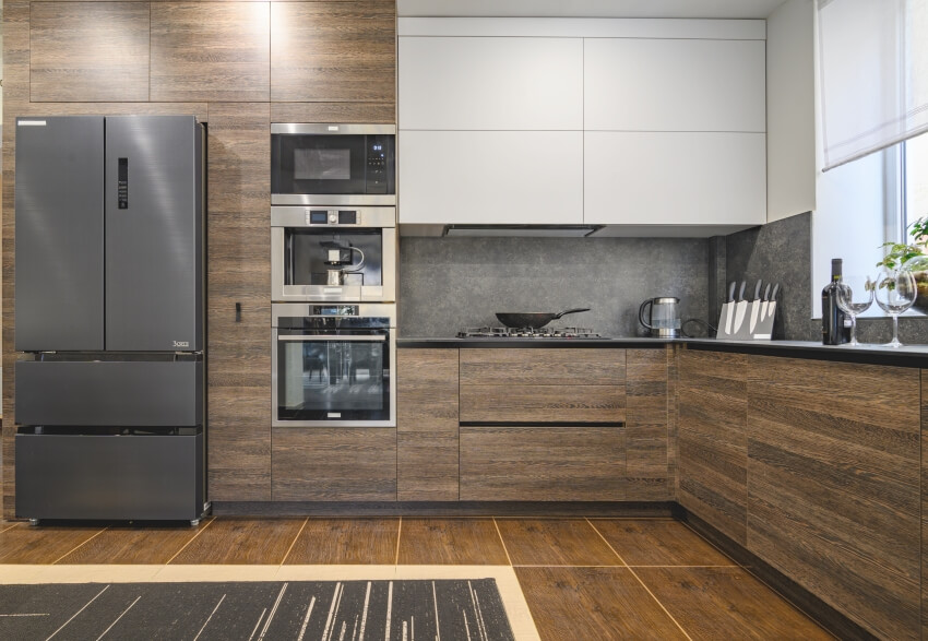 Large modern kitchen grey backsplash, wood tile floor, and dark brown laminate cabinets