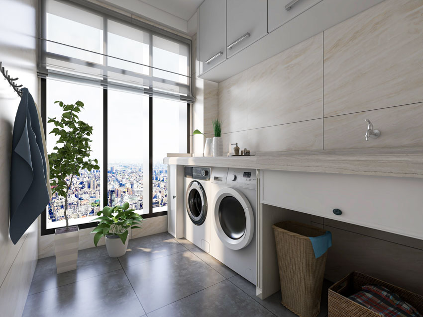 Laundry room with countertop, backsplash, washing machines, and windows