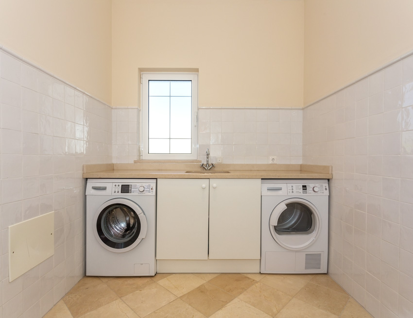 Laundry room with tile backsplash, wood floors, washing machine, and dryer