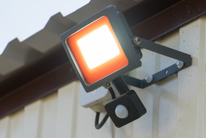 LED lighting fixture with motion sensor on metal wall