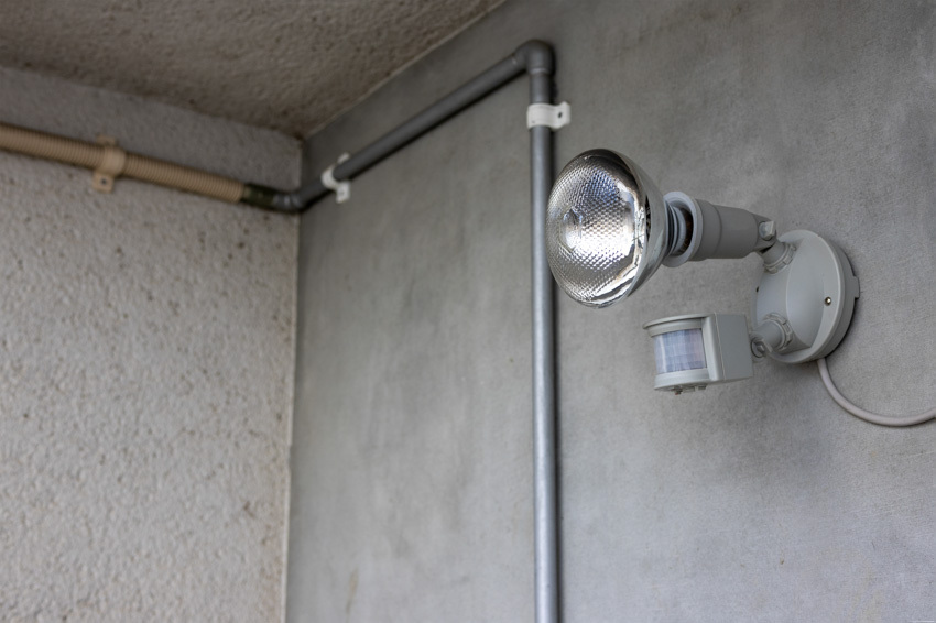 Lighting fixture with motion sensor on concrete wall
