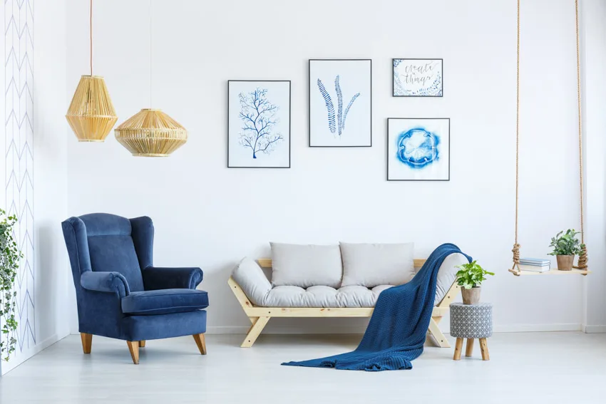 Blue cushioned chair, sofa, pendant lights, and decor pieces