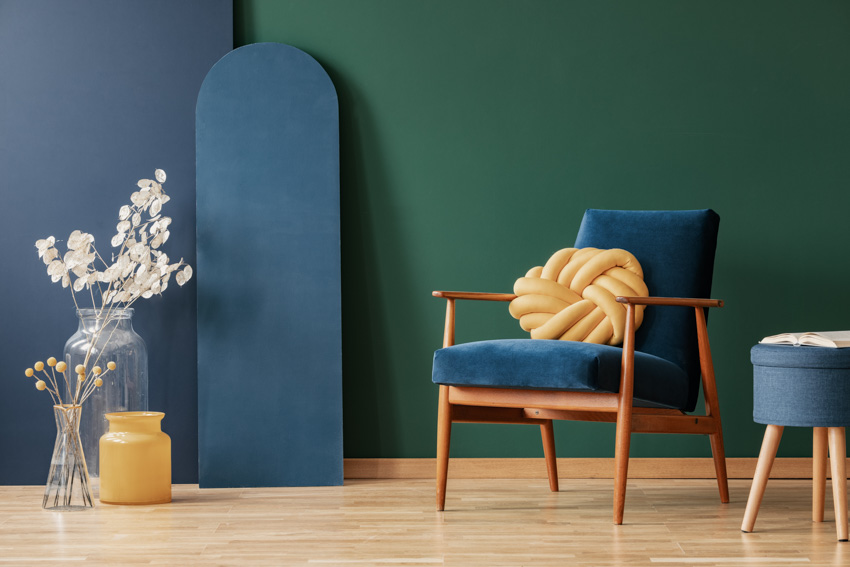 Bblue green wall, upholstered chair, and indoor decor pieces