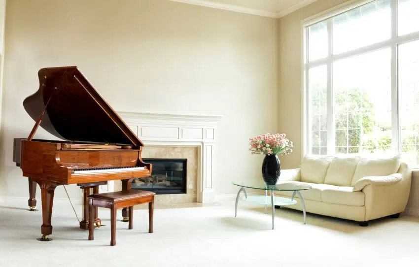Brown piano, fireplace and large window