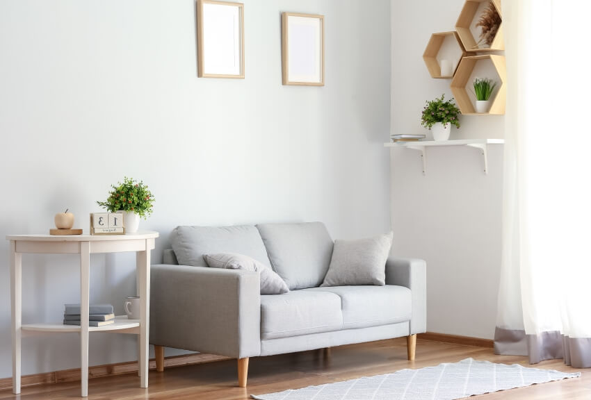 Room with floating honeycomb shelves, loveseat, and white half-circle table and rug