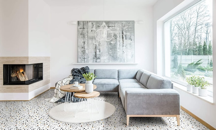 Living room with grey sofa, fireplace, large windows, terrazzo floor, and pendant light