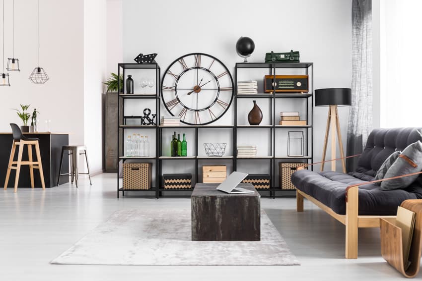 Living room with analog clock, open shelving and white rug