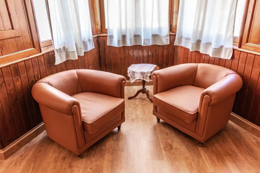 Club chairs, window curtains, and wood floors