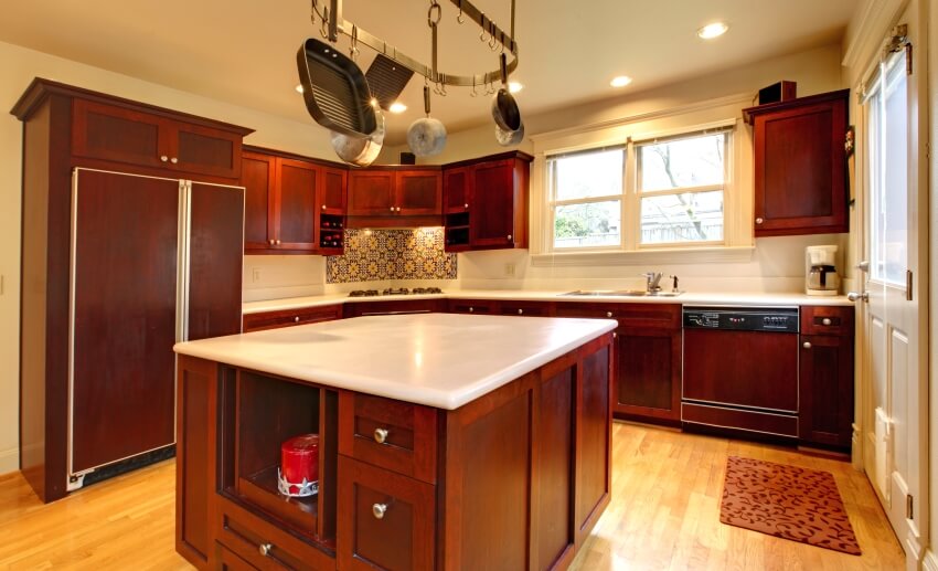 Luxury cherry wood kitchen with pot rack above island with white countertop