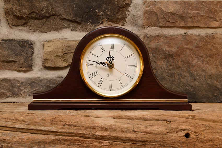 Mantel clock on piece of wood
