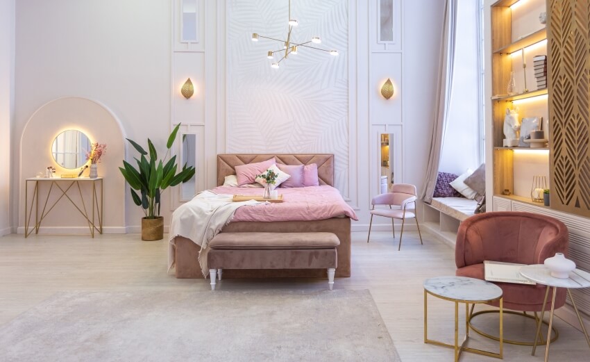 Modern bedroom in soft pastel colors with decorative lighting, and velvet chair and bench