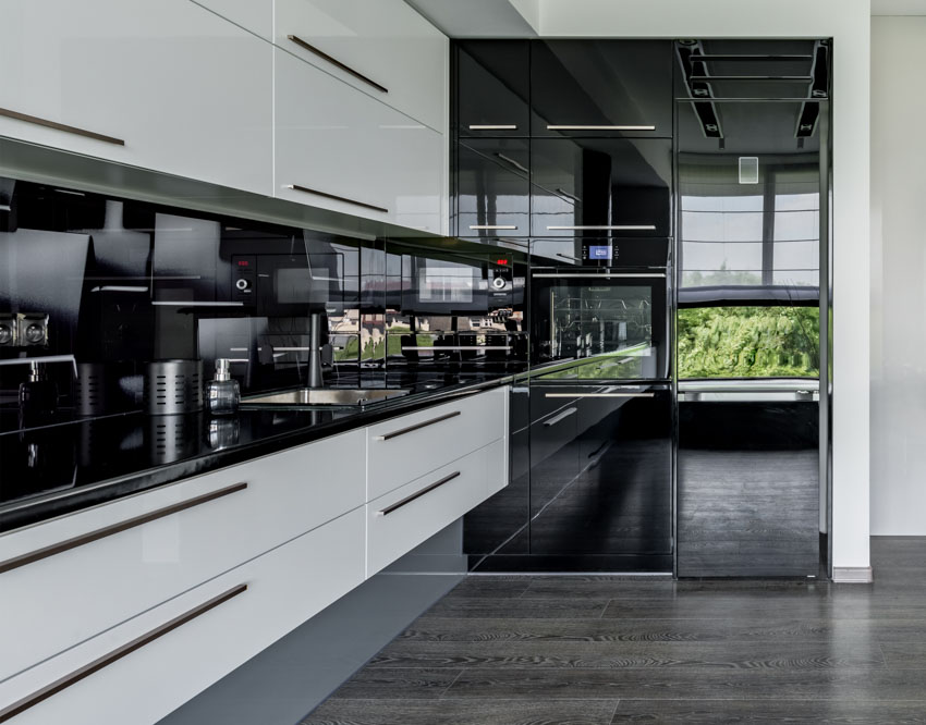 Kitchen with cabinets that are floating, countertops, black backsplash, and wood look tile floor